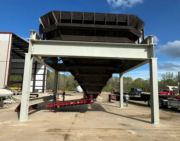 Fabricated steel hopper on a painted support structure in the shop yard