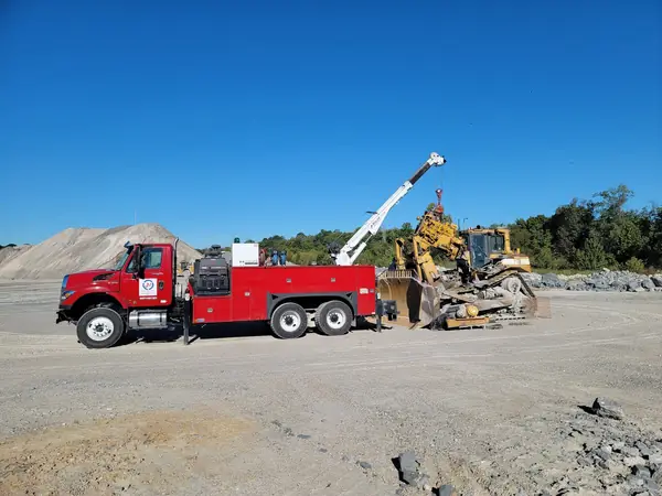 Field service truck working on heavy equipment at a quarry